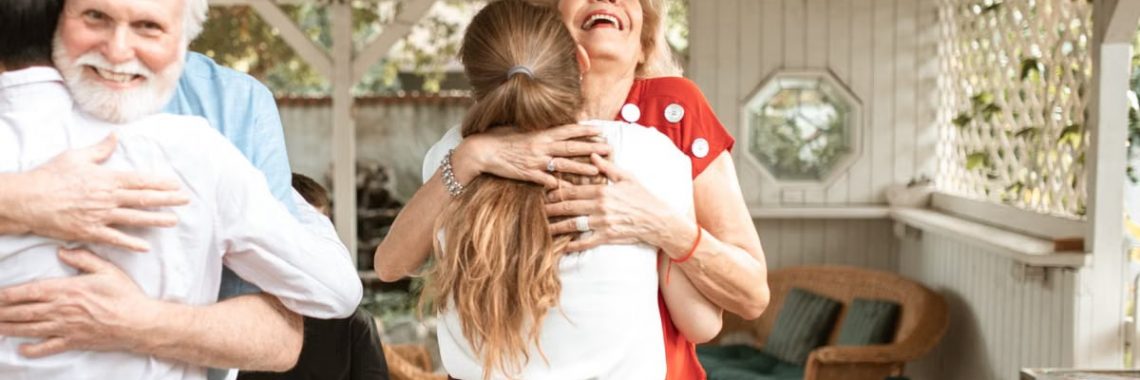 A heartwarming reunion with family members hugging and smiling in a cozy indoor setting.